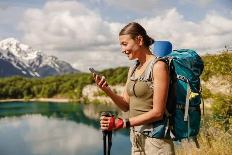 Hiker Using Smartphone while Enjoying the Beautiful Nature at a Scenic Mountain Stock Photos