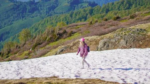 Hiker walking across a snowy patch in the beautiful mountains of Georgia Stock Photos