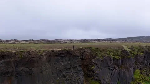 Hiker Walking Along Basalt Cliffs in Iceland Lava Fields Stock Footage 341481389