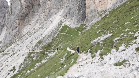 Hiker-walking-alpine-trail-dramatic-rocky-peaks Vídeos de archivo 334294514