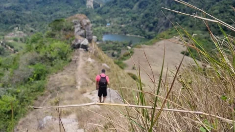Hiker Walking Down Scenic Mountain Ridge with Lake View Stock Footage 345103385