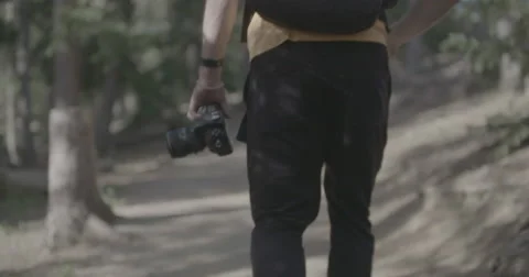 Hiker walking down trail with camera Stock Footage 65147516