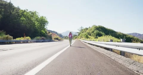 Hiker Walking on Empty Road Through Scenic Countryside 스톡 동영상 323908242