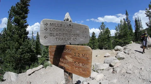 Hiker walking past Trailhead Stock Footage 33579361