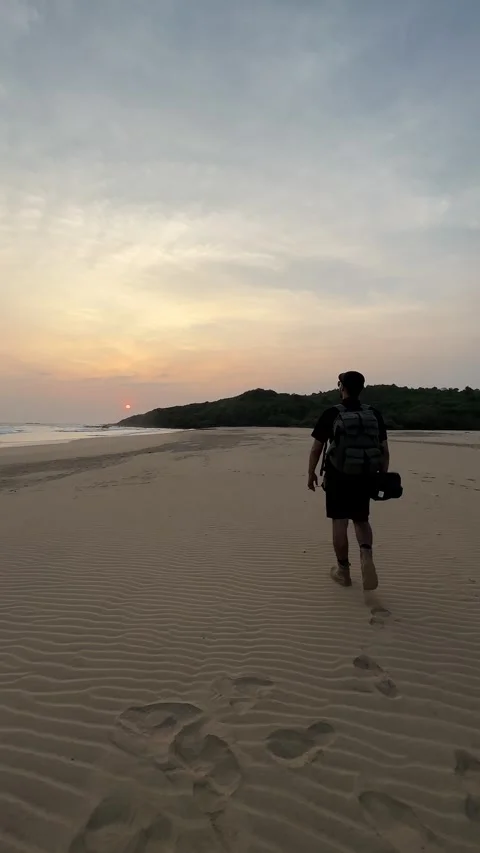 Hiker Walking on Sandy Beach at Sunset, Tracking Shot, Vertical Stock Footage 324772804