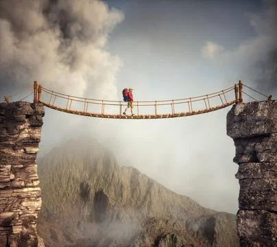Hiker walking on a suspension bridge between mountains. Ilustração Stock