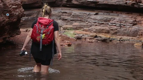 Hiker walking through knee deep water in Hancock Gorge in Karijini NP Video stock 71109273