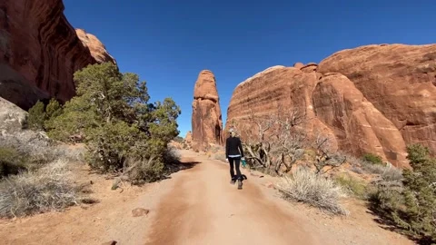 Hiker walking through the rock formations of Arches National Park 스톡 동영상 192069191
