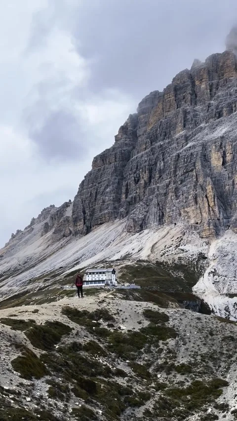 Hiker Walking Toward Camera with Tre Cime Behind Stock Footage 330437339