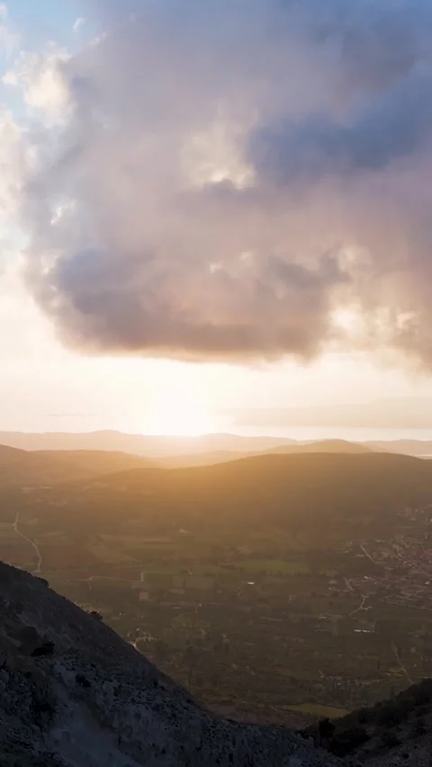 Hiker walking towards setting sun over rural landscape Video stock 290451185