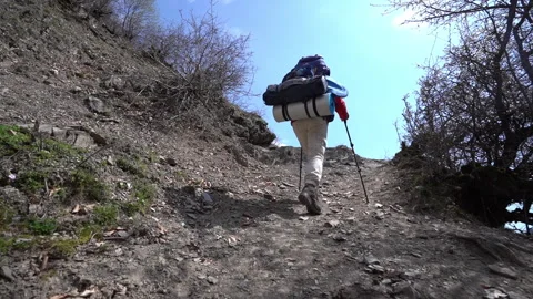 Hiker Walking Uphill on Mountain Path 動画素材 303662617