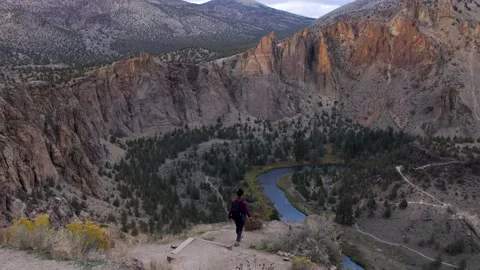 Hiker walks to cliffs edge at Smith Rock State Park Stock Footage 132659976