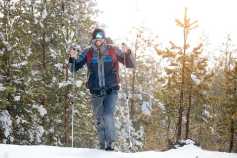 Hiker in winter mountains. Man with backpack trekking in mountains. Winter hi Stock Photos