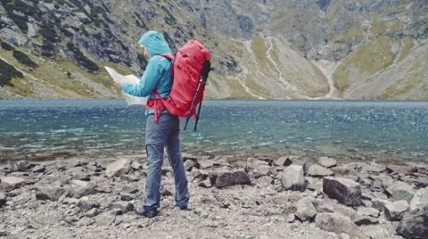Hiker woman using map at the mountain peak. Stabilized Slow Motion 120 fps. 스톡 동영상 55880352
