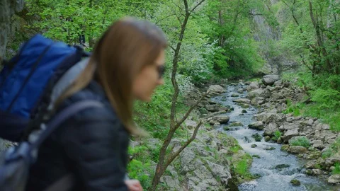 Hikers admiring a mountain river Stock Footage 99963605