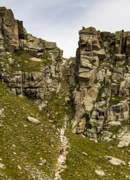 Hikers Climb Steep Path Between Rock Formations Stock Photos