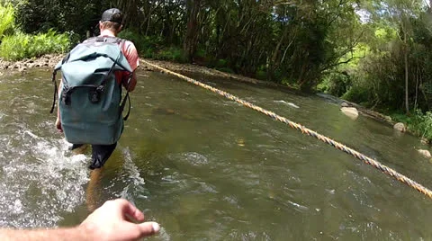 Hikers Cross River Using Rope Bridge Video stock 25853457