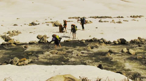 Hikers Crossing a River Stock Footage 62964316