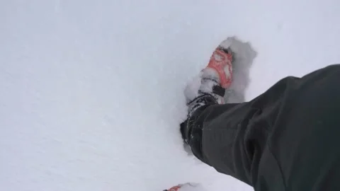 A hikers feet in deep snow while wearing black boots with orange crampons 스톡 동영상 146801423