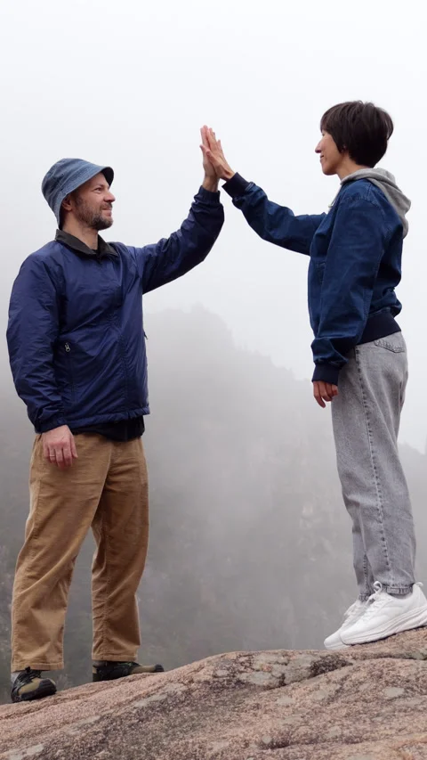 Hikers giving high five celebrating on mountain peak Stock Footage 303984341