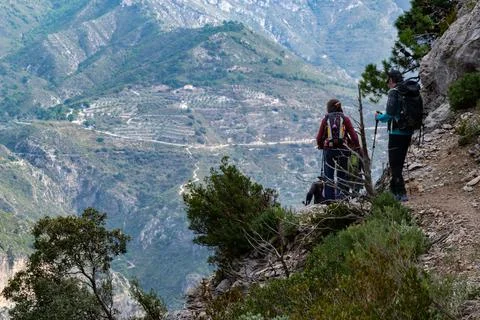 Hikers going down a path in Sierra de Tejeda and Almijara with a mountain wal Foto stock
