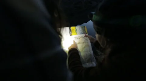 Hikers look at map in dark Stock Footage 50963612