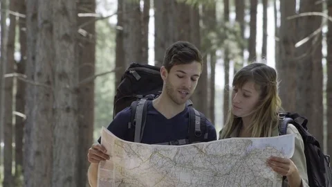 Hikers looking at map together in woods Stock Footage 75199424