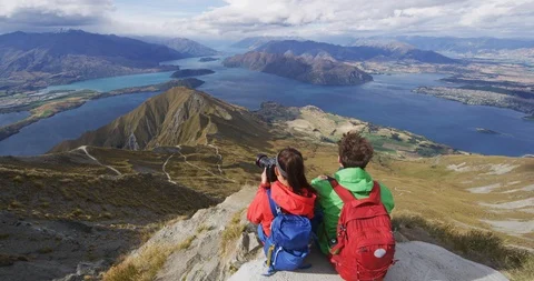 Hikers looking at view on mountain top summit on hiking travel vacation Stock Footage 96774419