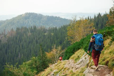 Hikers making their way down a rocky trail in the mountains Stock Photos