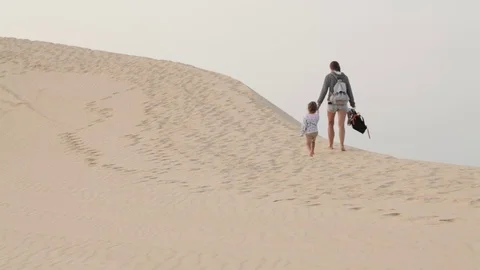 Hikers mother and daughter walking in desert Stock Footage