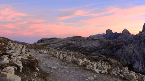 Hikers on the path of the Three Peaks  of Lavaredo, many little man stone signs Stock Footage 128950271