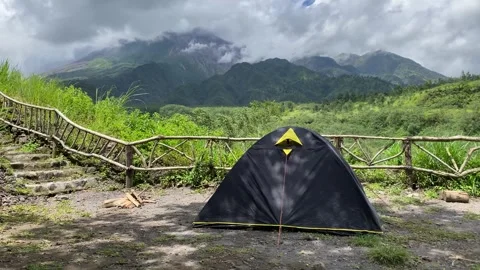 Hikers set up tents in Mount Merapi slopes, gentle breeze is blowing Stockbeeldmateriaal 347541379