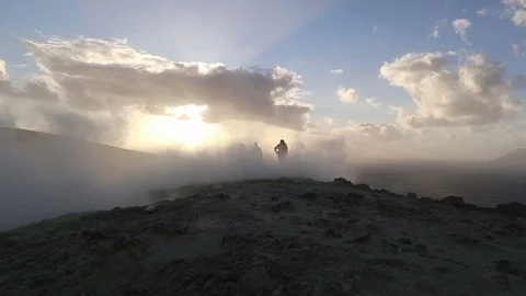 Hikers at sunset on the crater of Vulcano with sulfur fumaroles, Aeolian Islands Stock Footage