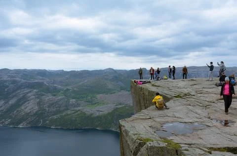 Hikers taking pictures while posing on the edge of the cliff Stock Photos