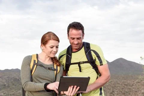Hikers using digital tablet in desert Fotos Stock