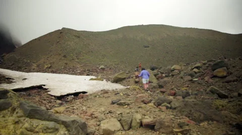 Hikers walk around snow capped glacier Stock Footage 59509884