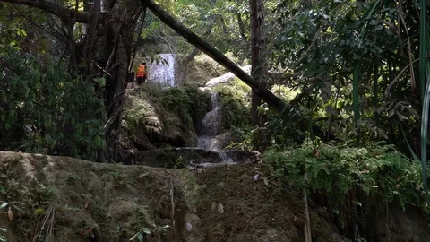 Hikers Walk Up a Multi-tiered Waterfall in Erawan Park, Thailand. Video stock 74292003