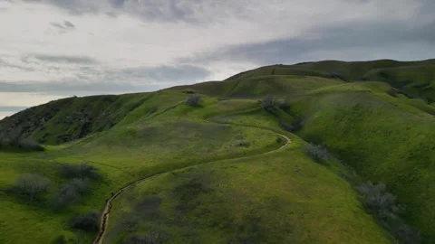 Hikers walking down Grassy Hillside Trail Overcast B Stock Footage 242040271