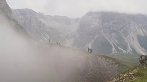 Hikers walking on mountain ridge with clouds rolling in Stock Footage 289087748