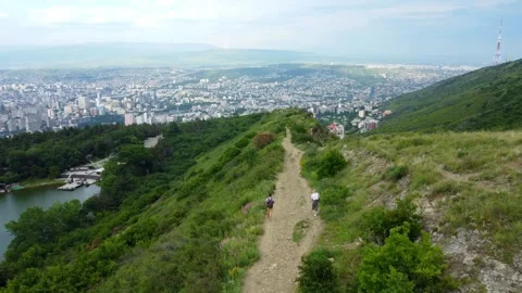 Hikers walking on mountain trail overlooking city Stock Footage 285652183