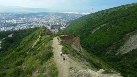 Hikers walking on mountain trail overlooking city 库存影片 285652190