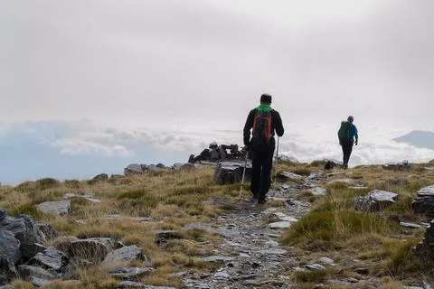 Hikers walking next to low clouds in Sierra Nevada Fotos de archivo