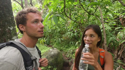Hikers walking in rain forest drinking water Stock Footage 31359925
