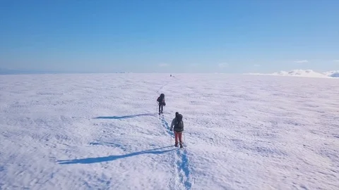Hikers walking on snow (glacier) with a rope, aerial shot in Iceland Stock Footage