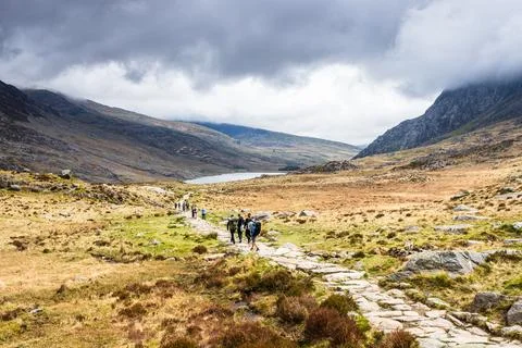 Hikers Walking on Stone Mountain Path Toward Llyn Ogwen, Snowdonia National.. Stock Photos