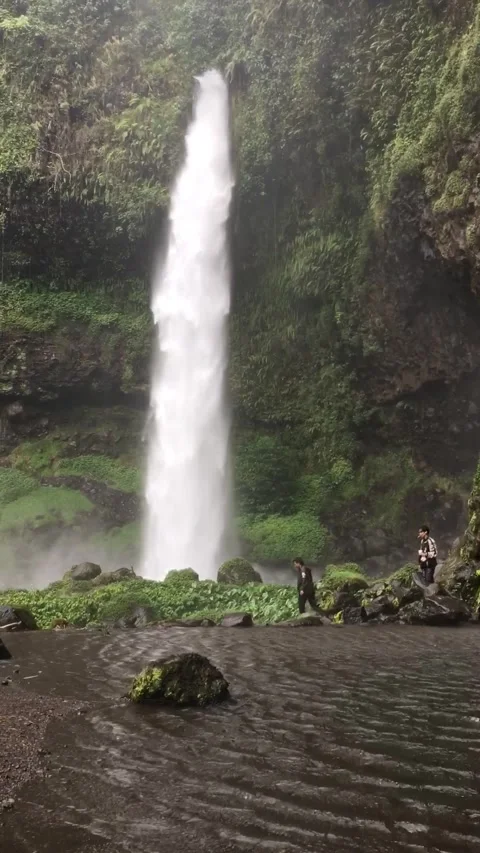 Hikers Walking Under The Tall Waterfall, West Java, Indonesia. 動画素材 344401426