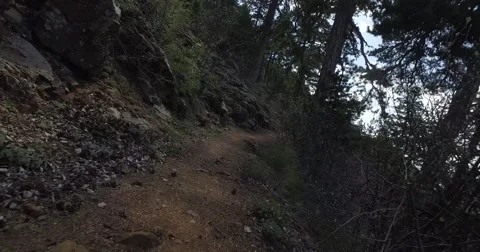 Hiking along a Shadowed Trail at the edge of a cliff Stockbeeldmateriaal 63562511