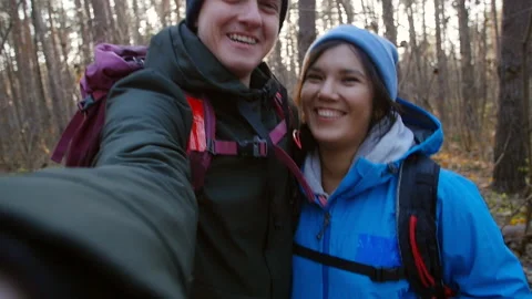 Hiking and Backpacking concept. Young happy couple with backpacks in the forest Stock Footage 100351926