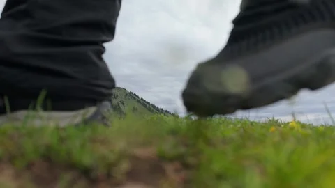Hiking boot steps through lush green mountain Stock Footage 345388486