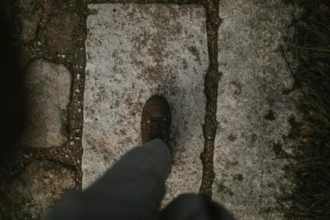 Hiking boot walking on a stone track. Stock Photos